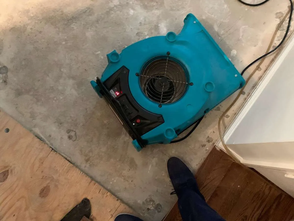 Air mover drying subfloor during Commercial Water Damage Restoration in West Vincent